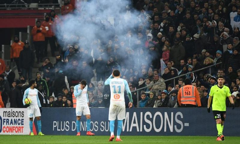 Kevin Strootman was left holding his face after a firework exploded at his feet. Jordan Amavi glared at the fans