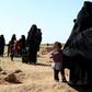Civilians fleeing from fighting between Syrian Democratic Forces (SDF) and Islamic State (IS) jihadists in the frontline village of Baghuz, await to be screened and registered by the SDF in eastern Deir Ezzor province on January 31, 2019