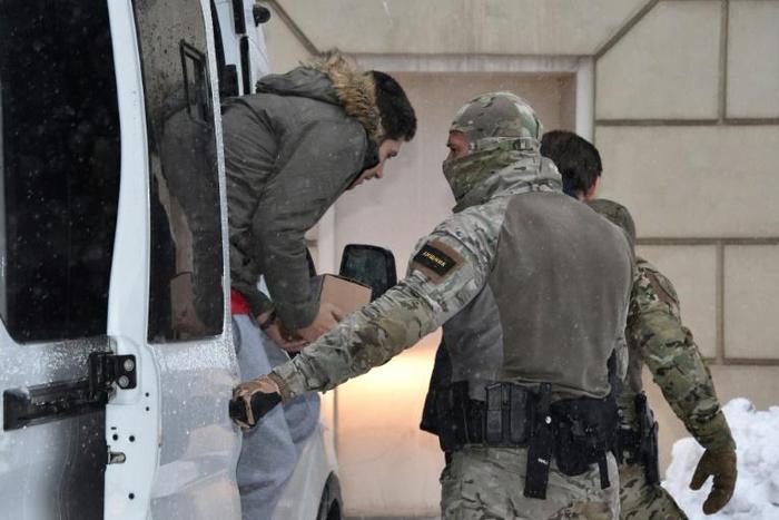 Russian security service officers escort a detained Ukrainian sailor to a Moscow cout which extended the pre-trial detention of 12 of the 24 captured seamen
