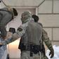 Russian security service officers escort a detained Ukrainian sailor to a Moscow cout which extended the pre-trial detention of 12 of the 24 captured seamen