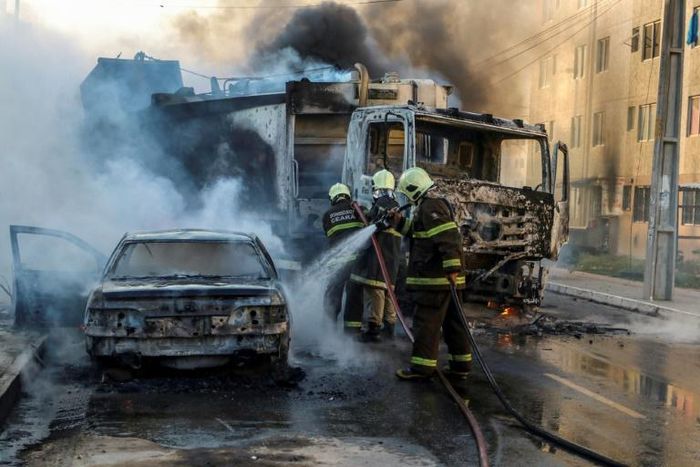 This picture released by O Povo shows firefighters putting out a burning truck and car during a wave of gang violence in Brazil's northeastern Ceara state, in Fortaleza, Ceara state, Brazil on January 3, 2019