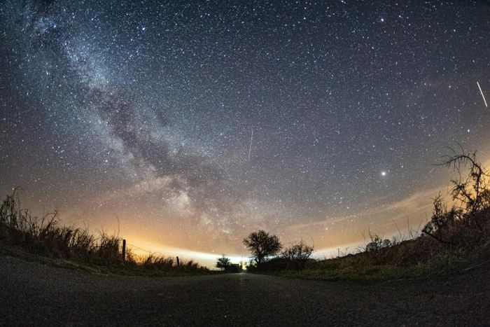 The milky way and meteors of the April Lyrids annual meteor shower in the night sky over the Baltic Sea