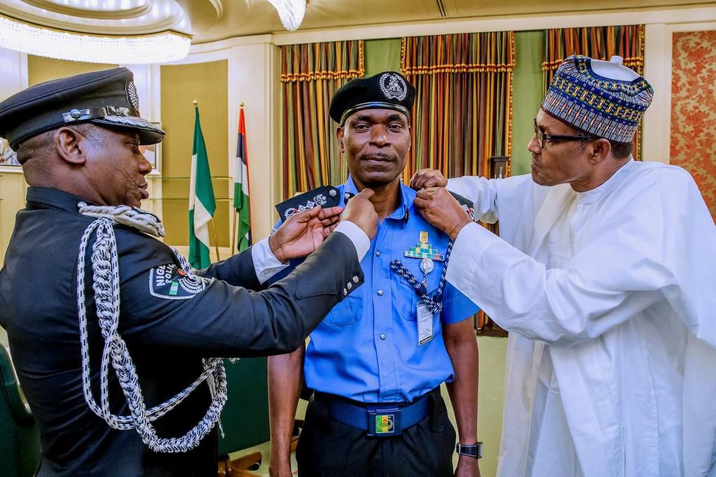 Mohammad Adamu (middle) decorated by Idris Ibrahim (left) and President Muhammadu Buhari (right) as the new Inspector-General of Police [Twitter/@NGRPresident]