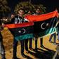 Libyans hold their national flags during a celebration marking the seventh anniversary of the revolution which toppled and killed veteran strongman Moamer Kadhafi in the eastern city of Benghazi on February 17, 2018