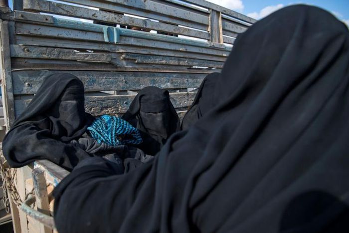 Women and children flee the Islamic State group's last pocket of territory in Syria in a truck