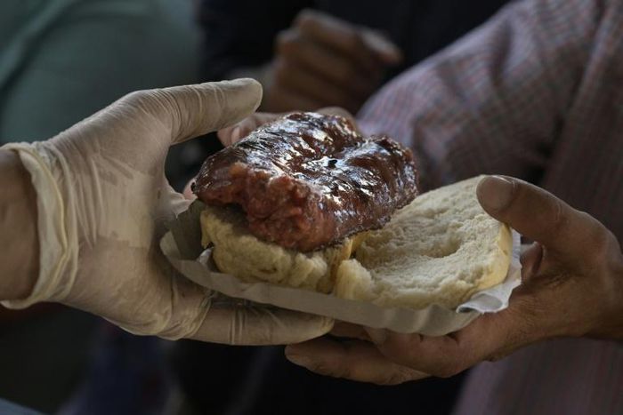 A man receives a "choripan" (grilled sausage on bread) for free during a protest in Buenos Aires