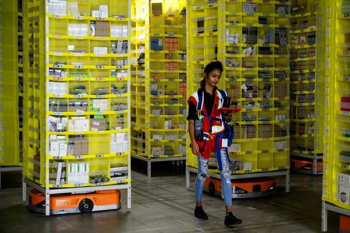 Amazon employee Deasahni Bernard moves among robots at the 855,000-square-foot Amazon fulfillment center in Staten Island February 5, 2019