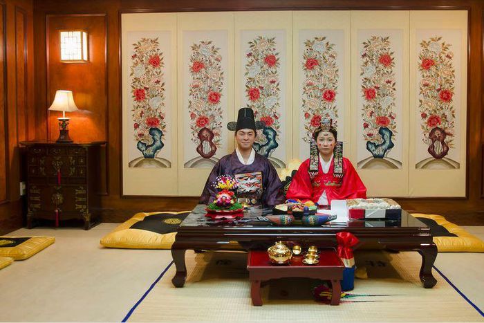 A korean couple pose for pictures at their wedding ceremony