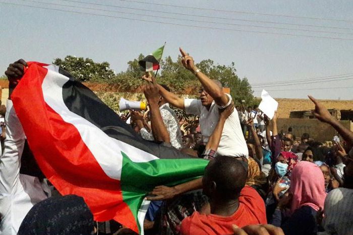 Sudanese protesters wave the national flag during an anti-government demonstration in the capital Khartoum's twin city of Omdurman on January 31, 2019