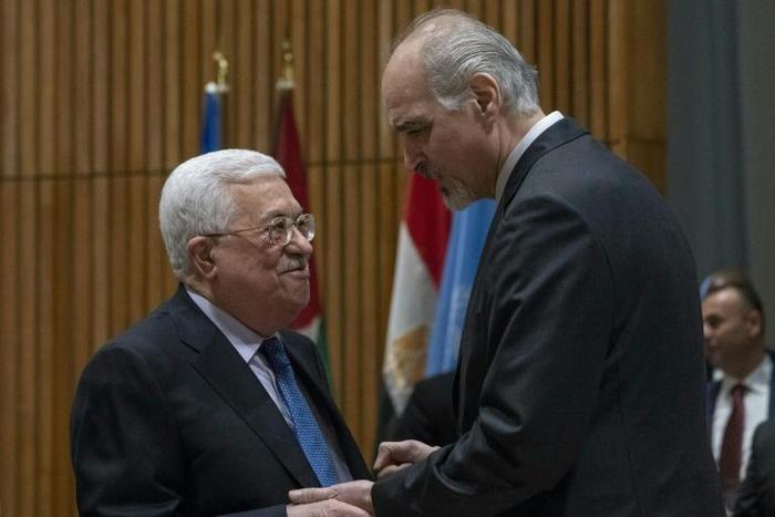 Palestinian president Mahmud Abbas (L) speaks with Syria's Ambassador to the United Nations Bashar Jaafari before meeting of the United Nations Group of 77 and China at the United Nations