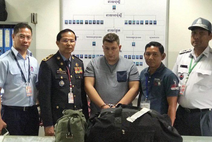 A Romanian, Narcis-Manuel Olaru (center), was arrested with 11 pounds of methamphetamine and led Cambodian Police to his three Nigerian accomplices and a fellow Romanian