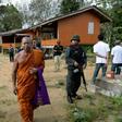 Buddhist monks and armed Thai police at the compound of the Rattanaupap temple, which was attacked by gunmen