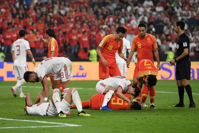Players check-up on teammates after a collision in the Asian Cup quarter-final between China and Iran