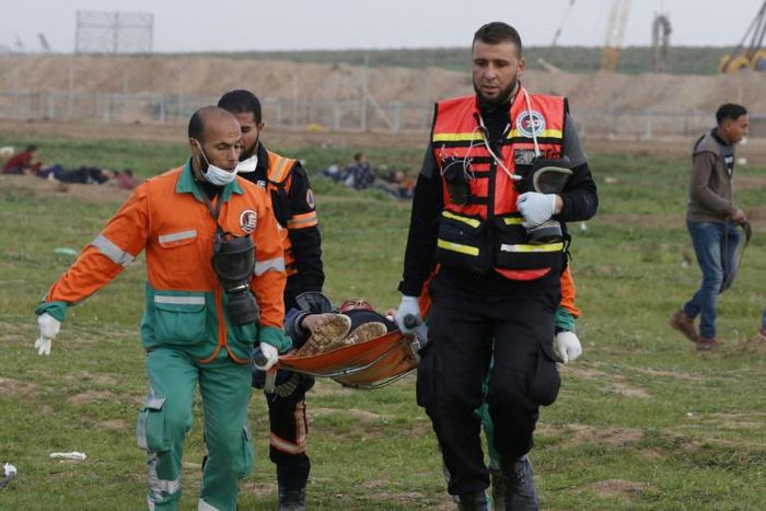 Palestinian paramedics evacuate a protester near the fence separating the Gaza Strip from Israel, east of Gaza City, on February 1, 2019