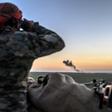 A Syrian Democratic Forces fighter watches the village of Baghouz where the Islamic State group has its last sliver of territory