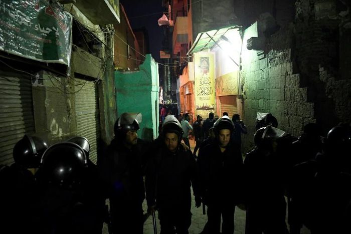 Egyptian riot police block access to the street where the body of a suicide bomber lay covered in a sheet behind al-Azhar Mosque in Cairo