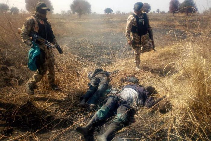 Nigerian soldiers stand over the corpses of neutralised Boko Haram terrorists [Facebook/HQ Nigerian Army]