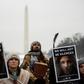 Activists hold up signs as they listen to speakers during the Indigenous People's March on the National Mall in Washington, DC,
