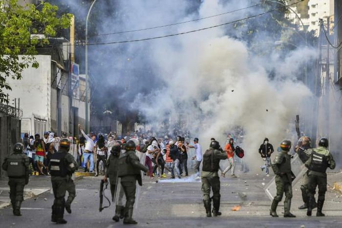 Riot police clash with opposition demonstrators in Caracas