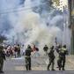 Riot police clash with opposition demonstrators in Caracas