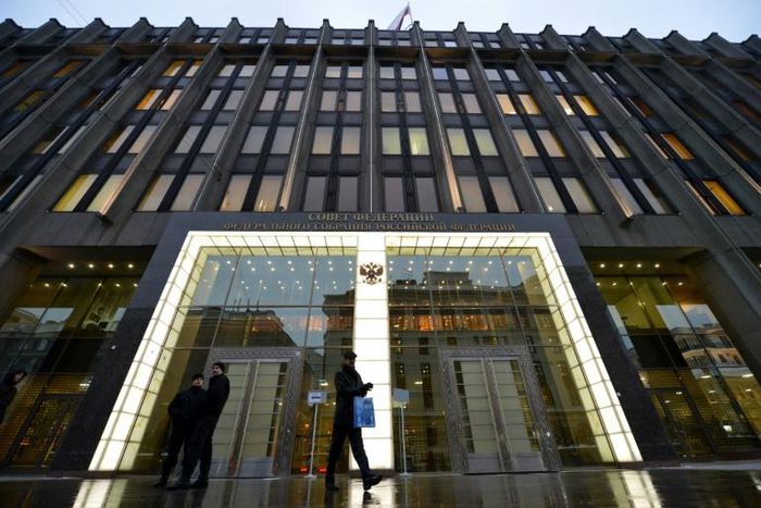 Security agents (L) stand guard outside the Federation Council, the upper house of Russia's legislature, where Senator Rauf Arashukov was arrested in connection with two murders