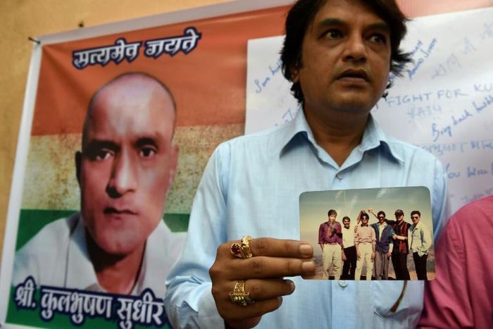 A supporter of Jadhav holds a photograph of himself and the alleged spy along with other friends from the Mumbai neighbourhood where they all grew up