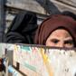 Women and children fleeing the Islamic State group's last holdout in eastern Syria pack into an open-back truck on February 11, 2019, for the long journey across the desert to a camp for the displaced