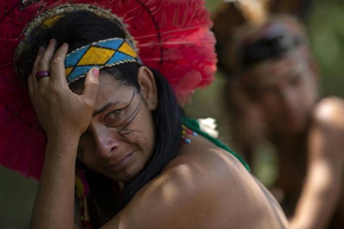 An indigenous woman of the Pataxo Ha-ha-hae community crying as she looks out over the Paraopeba river, filled with mud after a disastrous dam collapse in Brazil's Minas Gerais state