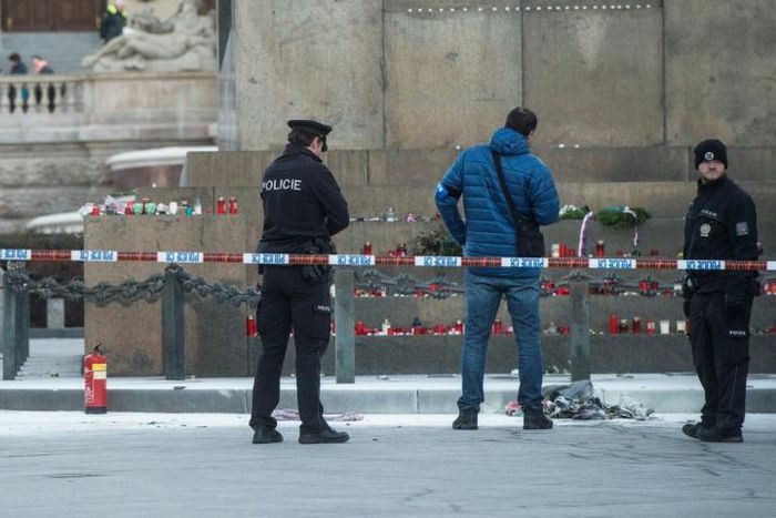 Police officers investigate at the scene where a man set himself on fire in Prague