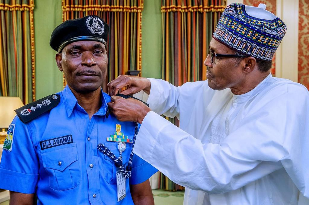 President Muhammadu Buhari decorates Mohammed Adamu as the new Inspector-General of Police [Twitter/@NGRPresident]