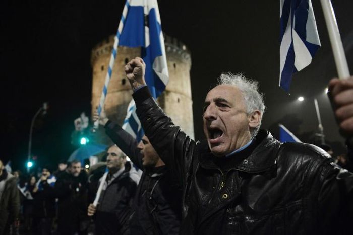 People hold Greek flags and shout slogans in Thessaloniki on December 14, 2018, as they protest Macedonia's name change, which they object to because of the northern Greek province of the same name
