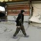 A fighter from the Syrian Democratic Forces (SDF) walks past shops with their fronts painted with the Arabic phrases "beware a sniper" and "caliphate state", in the Syrian town of Hajin on January 27, 2019