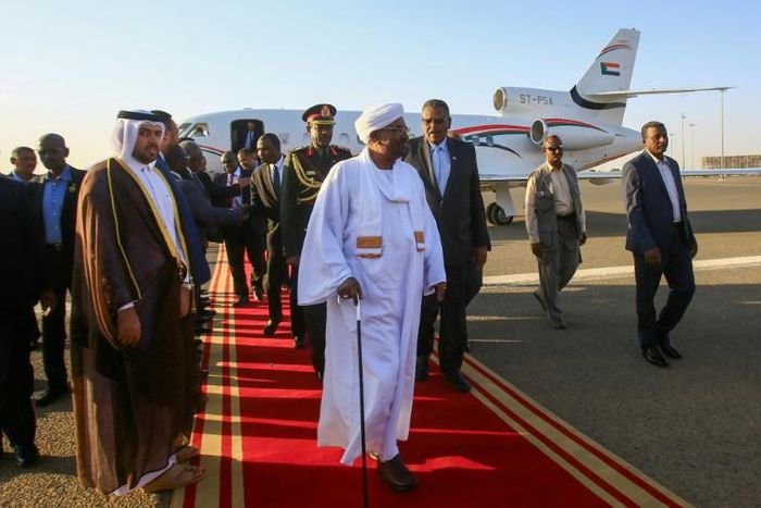 Sudan's President Omar al-Bashir (C) is received upon his return from Qatar at Khartoum international airport