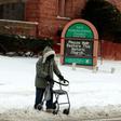 A person with a walker crosses Canfield Avenue in Detroit, Michigan