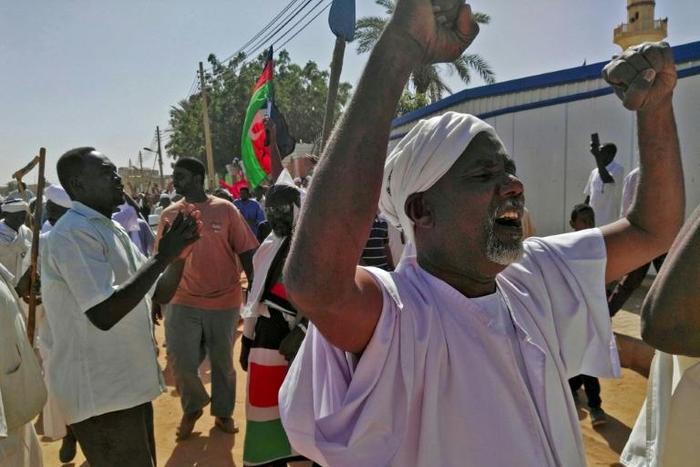 Sudanese men shout slogans during an anti-government protest following Friday noon prayers on January 18, 2019 outside a mosque in Omdurman