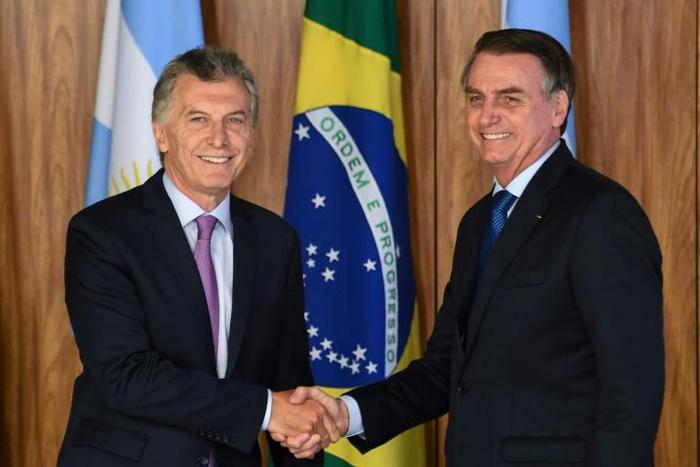 Argentina's President Mauricio Macri (L) and Brazilian President Jair Bolsonaro shake hands after signing an agreement at Planalto Palace in Brasilia, on January 16, 2019