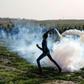 A Palestinian protester throws a tear gas canister back towards Israeli forces during clashes along the Gaza border on January 25, 2019