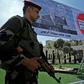 A member of the Palestinian security forces stands in front of a poster of President Mahmud Abbas, during a protest in Bethlehem on September 26, 2018 against Washington's decision to cut aid