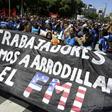 Demonstrators hold a banner reading "We, the workers, will not kneel before the IMF," during a protest February 13, 2019