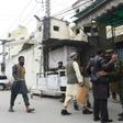 A Pakistani police officer frisks worshippers as they arrive for Friday prayers before entering a mosque of banned militant group Jamaat-ud-Dawa