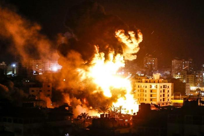 Fire and smoke billow above buildings in Gaza City during reported Israeli strikes on March 25, 2019