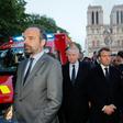 French Prime Minister Edouard Philippe (L), and French President Emmanuel Macron (3rd L) gather near the entrance of the Notre-Dame Cathedral in Paris, as flames engulf its roof