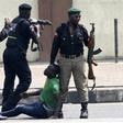 Nigerian police members beating up a man