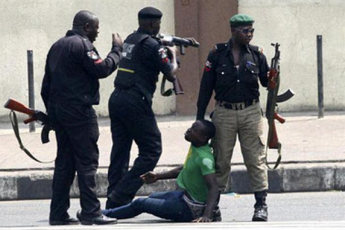 Nigerian police members beating up a man