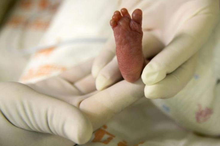 A pediatric nurse holds a premature baby after feeding him at Medellín's General hospital on August 20, 2014 in Medellin, Colombia. A Greek mother of the first baby born using DNA from three people has praised the revolutionary technique