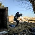 A fighter with the Syrian Democratic Forces (SDF) takes aim with his Kalashnikov assault rifle after seeing a man walking towards his position in the town of Baghouz, in the eastern Syrian province of Deir Ezzor, on March 9, 2019