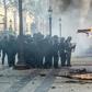 French riot police forces outside a burning restaurant on the Champs-Elysees in Paris on Saturday