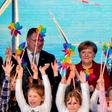 German Chancellor Angela Merkel joined Norway's Minister of Petroleum and Energy Kjell Borge Freiberg (left) and the chairman of energy group E.ON Johannes Teyssen (right) and a group of schoolchildren to open the new wind park