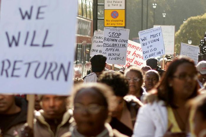 Chagos Islanders leave London's Houses of Parliament with protest signs on October 22, 2008