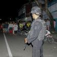 Officers stand guard after the explosion at the home of a suspected militant on Sumatra island